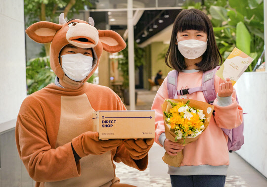 캐릭터 복장을 한 SKT 배송 담당자가 고객에게 스마트폰과 꽃다발, 맞춤선물 등을 전달하고 있다. SK텔레콤 제공